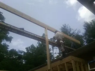 Carpenter setting a ridge beam over a new addition frame — Ice Dam Removal by Roofing Brothers in Woodway