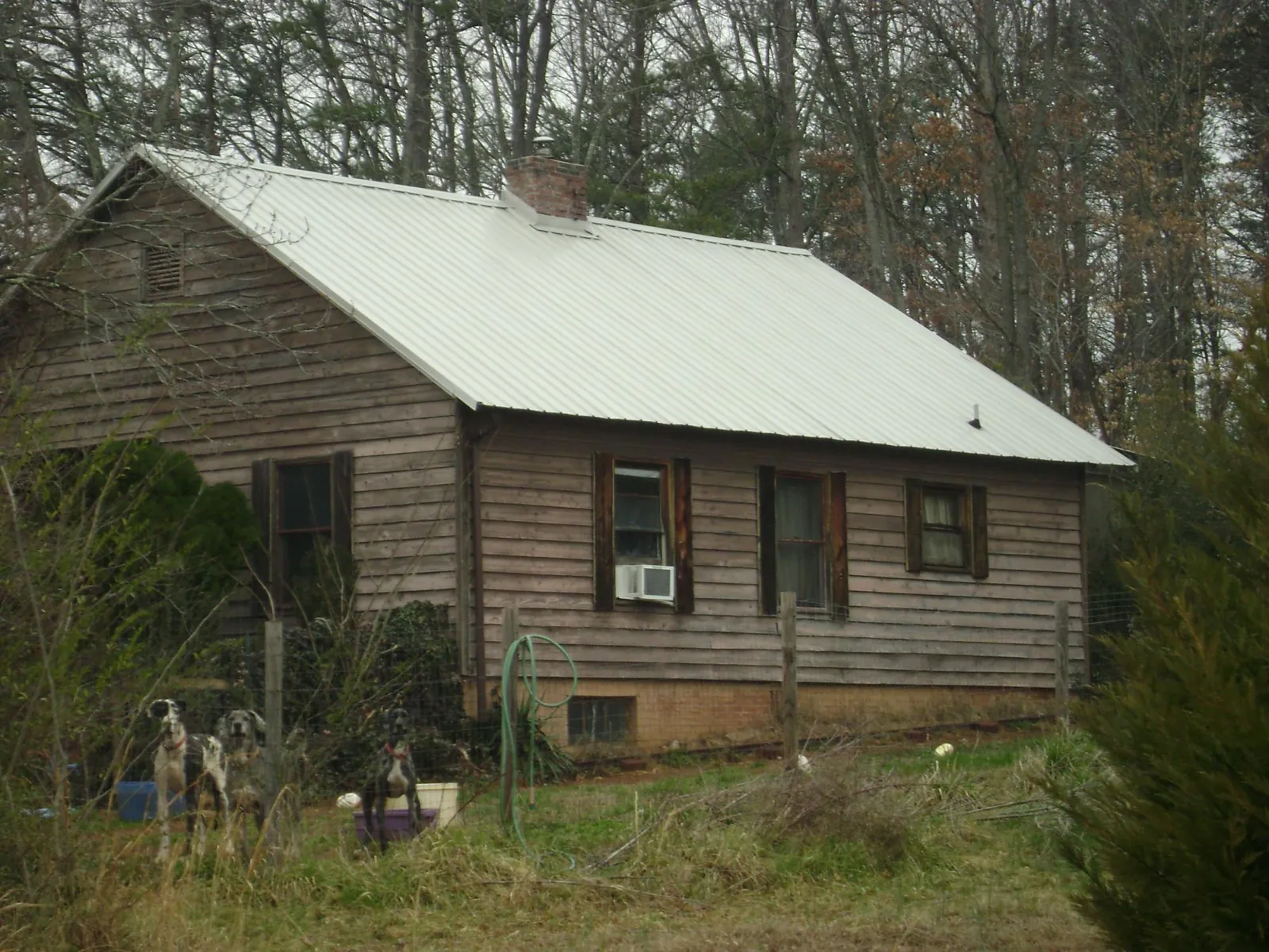 White metal roof on an old wood sided farmhouse, from a Metal Roof Installation job in Woodway